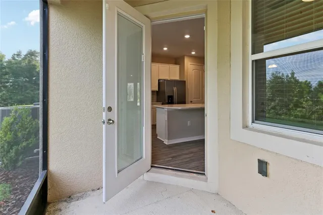 a view of a hallway with wooden floor and a bathroom