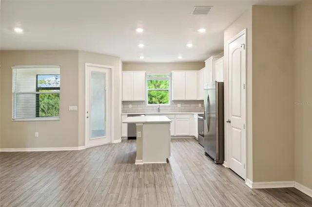 a kitchen with a refrigerator a sink and wooden floor