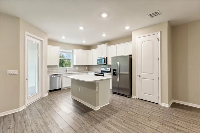 a kitchen with a refrigerator a sink and cabinets