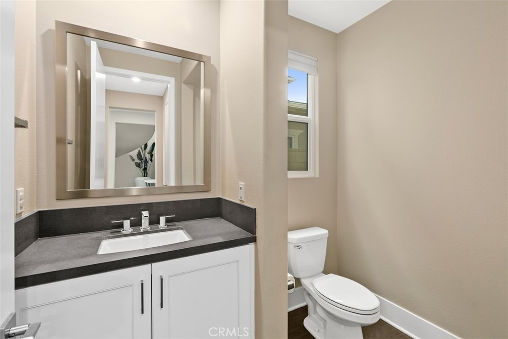 79 Gravity Irvine, CA 92618 - Photo 28 of 70 a bathroom with a granite countertop sink a toilet and a mirror