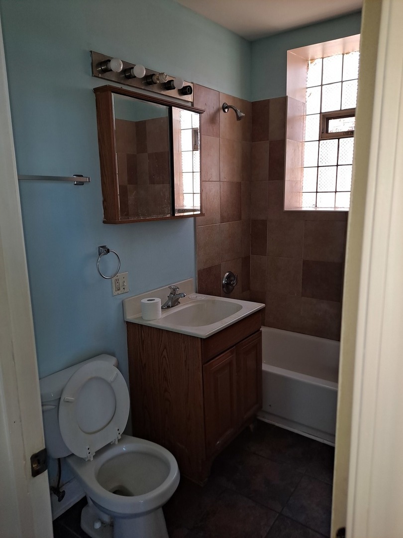 1640 South Springfield Avenue Chicago, IL 60623 - Photo 4 of 11 a bathroom with a toilet a sink and a window