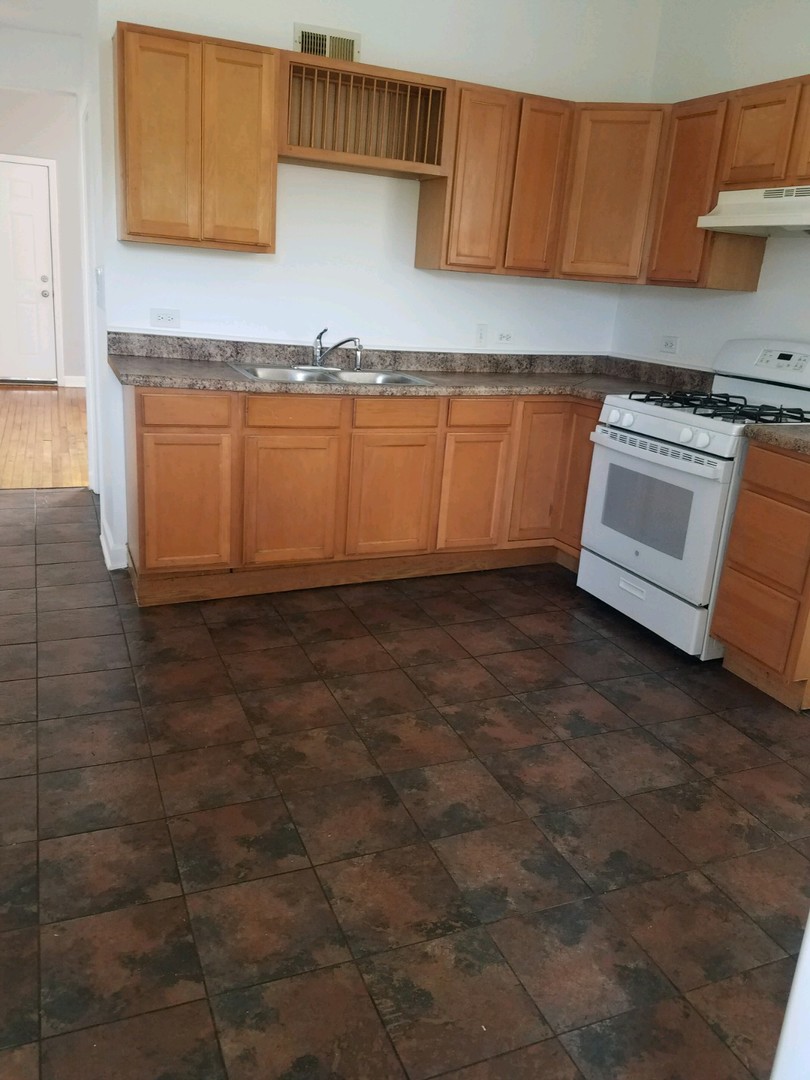 1640 South Springfield Avenue Chicago, IL 60623 - Photo 6 of 11 a kitchen with granite countertop a sink and a white cabinets
