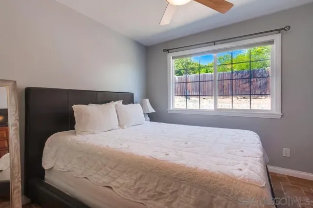a large bed sitting in a bedroom next to a window