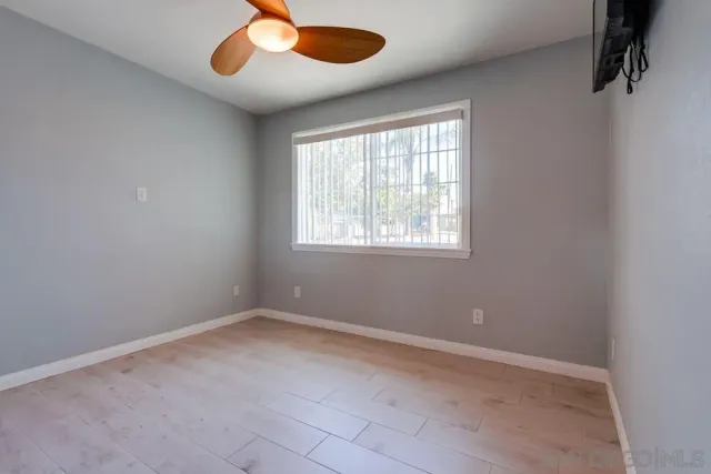 an empty room with windows and fan