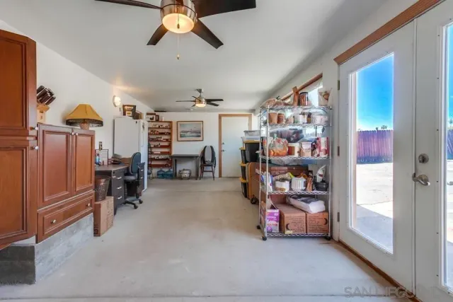 a view of a room with racks shoes and a chandelier