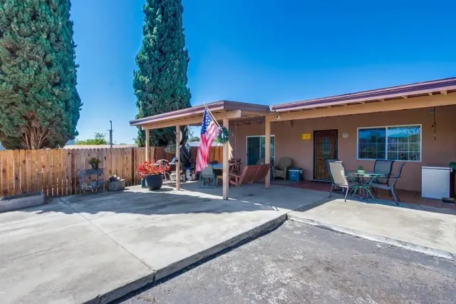a view of a patio with a table and chairs under an umbrella