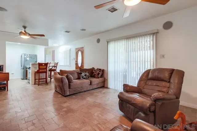 a living room with furniture ceiling fan and a window