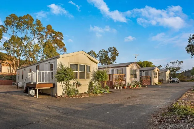 a front view of a house with a yard street and trees