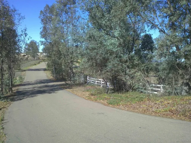 a view of a street with a house in the background