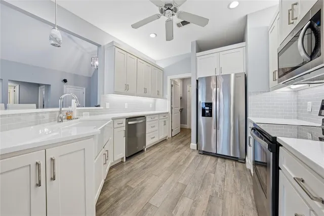a kitchen with a sink cabinets and wooden floor