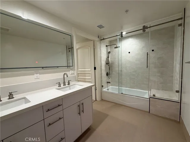 a bathroom with a tub shower sink mirror and a shower