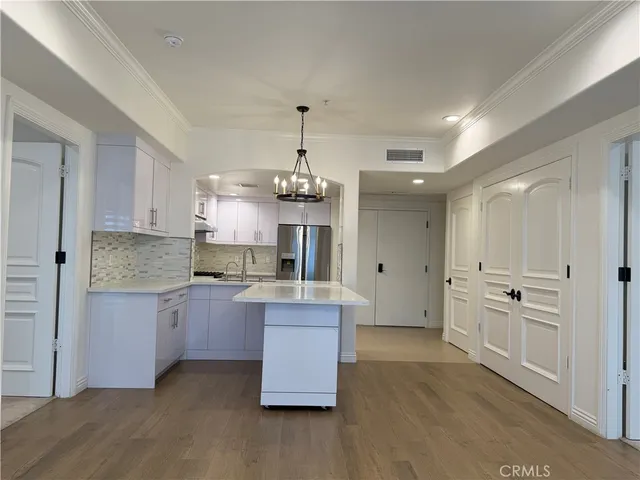 a kitchen with kitchen island white cabinets and refrigerator