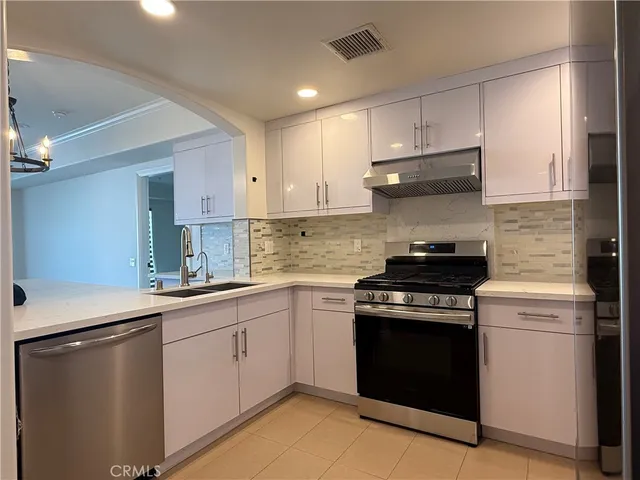 a kitchen with a stove sink and cabinets