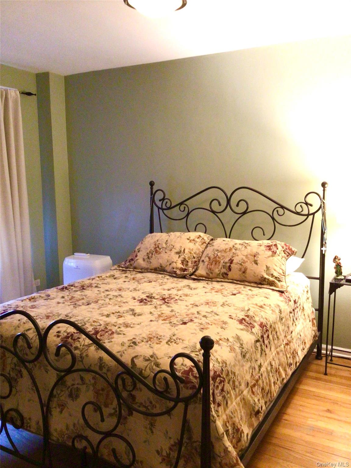 83-05 98th Street, Unit 5B Queens, NY 11421 - Photo 9 of 12 a bedroom with a bed and a mirror