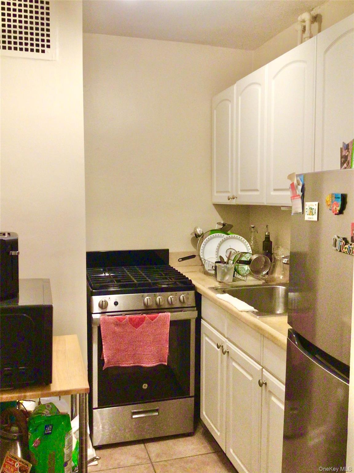 83-05 98th Street, Unit 5B Queens, NY 11421 - Photo 10 of 12 a kitchen with a stove and a microwave
