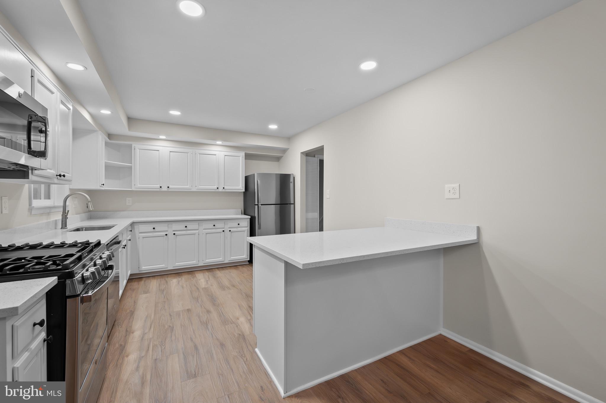 19420 Olney Mill Road Olney, MD 20832 - Photo 10 of 44 a kitchen with a sink a stove and cabinets