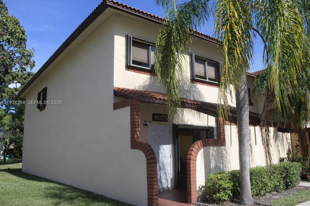 8925 Springtree Lakes Drive Sunrise, FL 33351 - Photo 5 of 19 a front view of a house with a yard