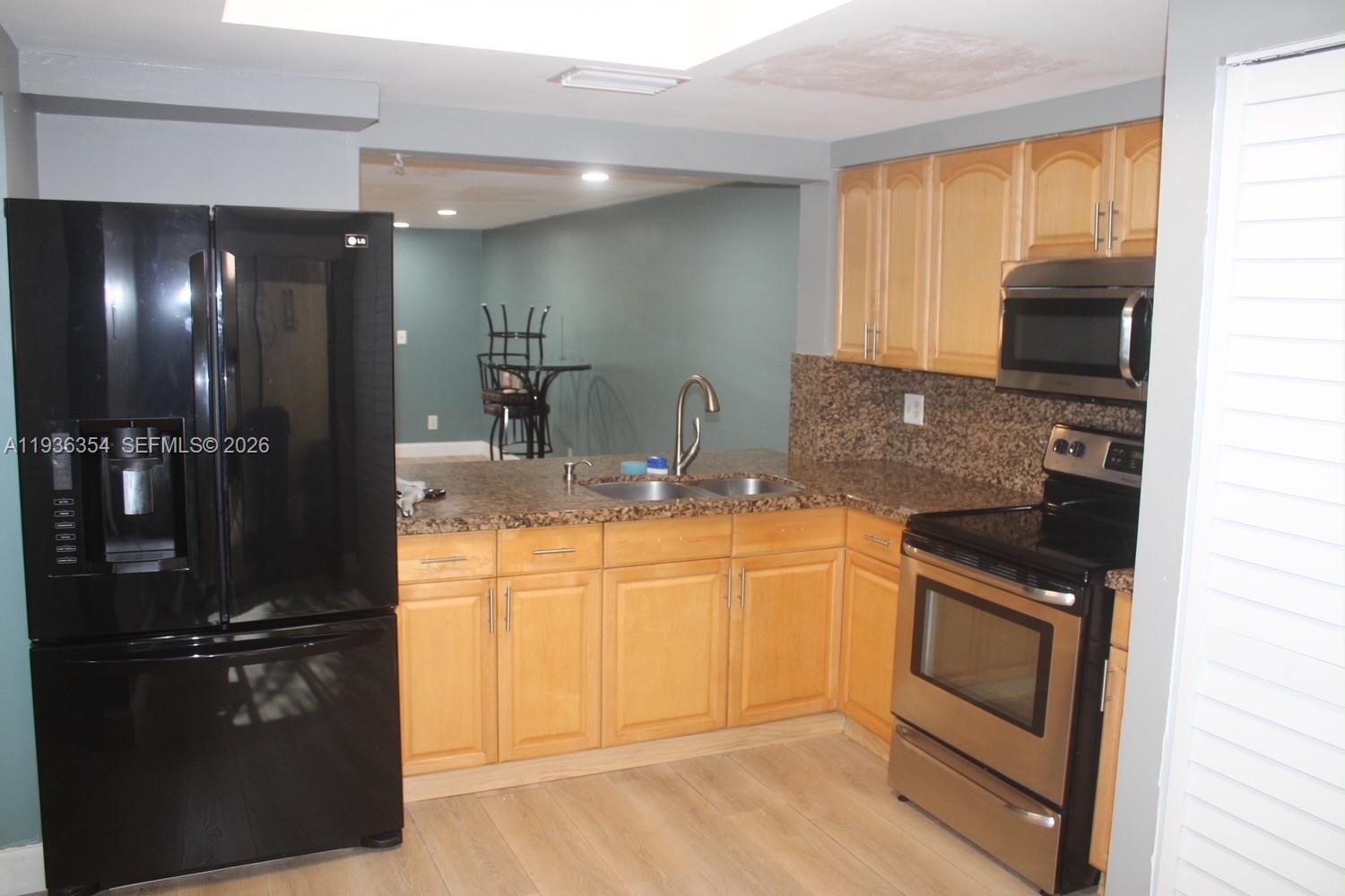 8925 Springtree Lakes Drive Sunrise, FL 33351 - Photo 8 of 19 a kitchen with granite countertop a refrigerator stove and sink