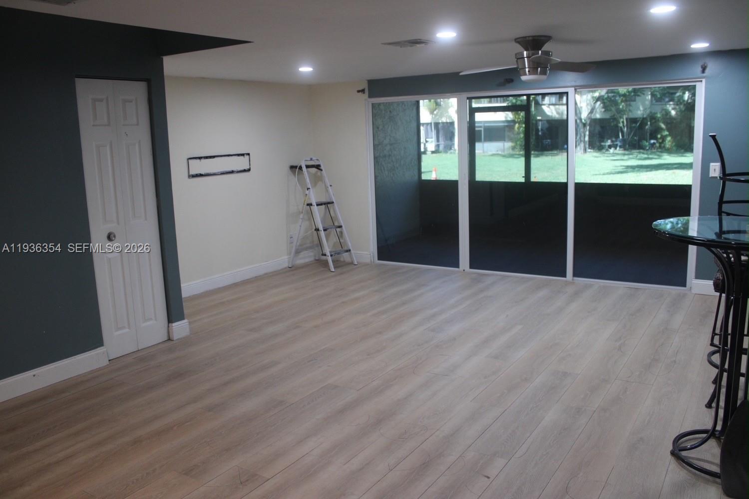 8925 Springtree Lakes Drive Sunrise, FL 33351 - Photo 9 of 19 an empty room with wooden floor and windows