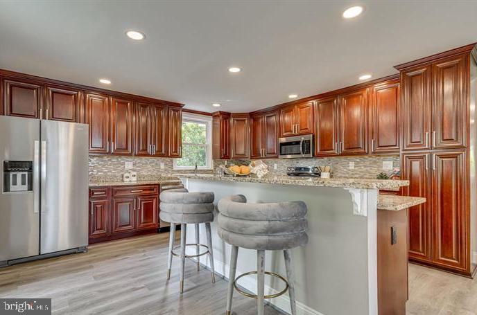4105 30th Street Mount Rainier, MD 20712 - Photo 17 of 98 a kitchen with stainless steel appliances granite countertop wooden cabinets a refrigerator a stove a sink and a microwave