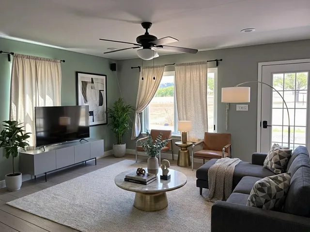 a living room with furniture a flat screen tv and a large window