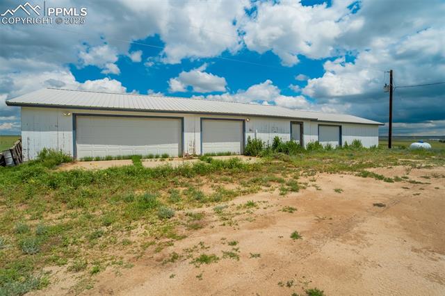 1435 Equestrian Point Yoder, CO 80864 - Photo 33 of 49 View of front of property with a garage, a metal roof, and an outdoor structure