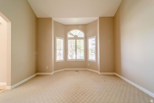 598 Hollow Creek Road Draper, UT 84020 - Photo 21 of 110 Bay window with arched transom, plantation shutters, and light-toned patterned carpeting