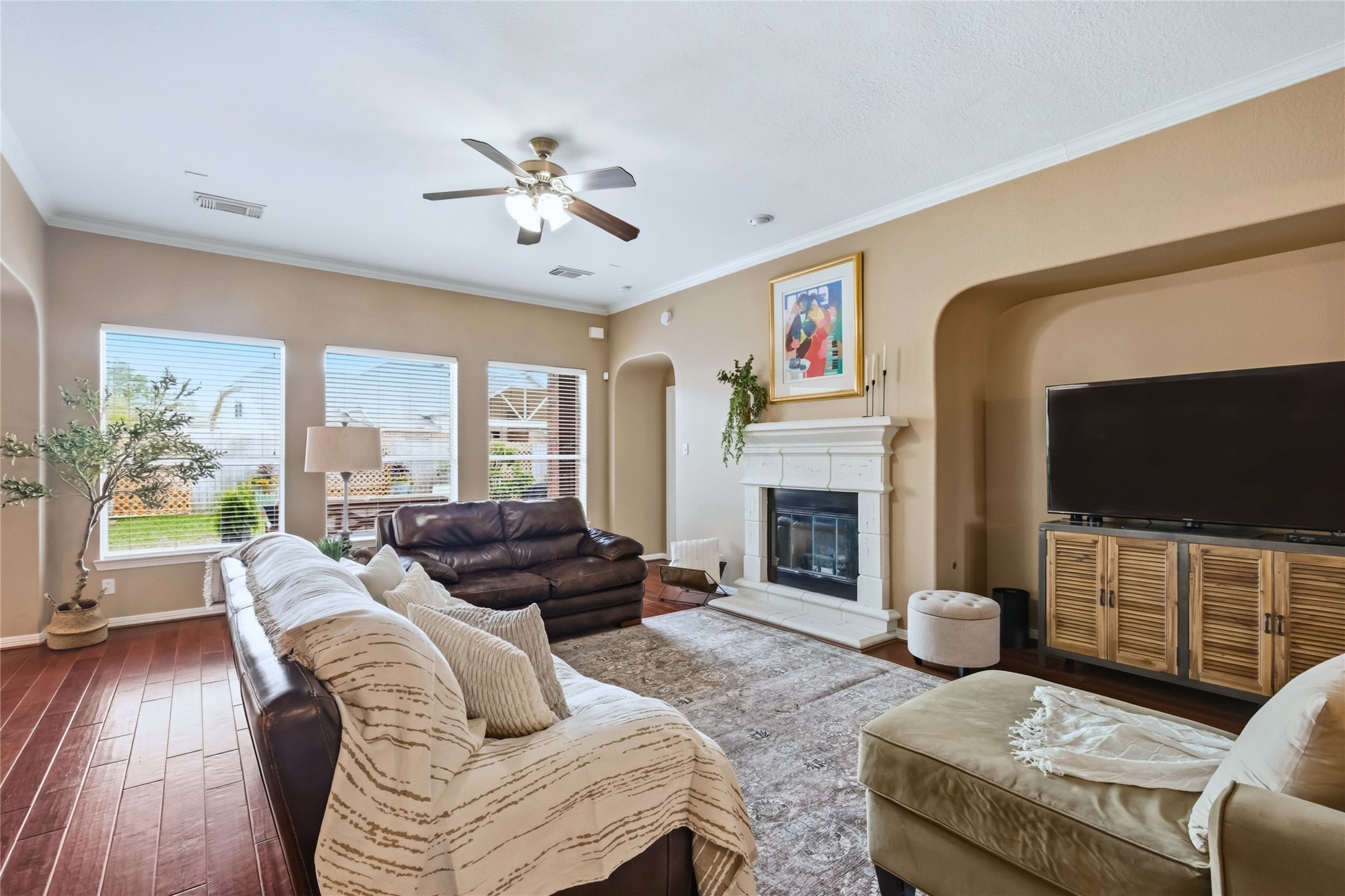 20722 Windrose Bend Drive Spring, TX 77379 - Photo 13 of 50 Bright and spacious living room featuring hardwood floors, a cozy fireplace, and large windows offering plenty of natural light.