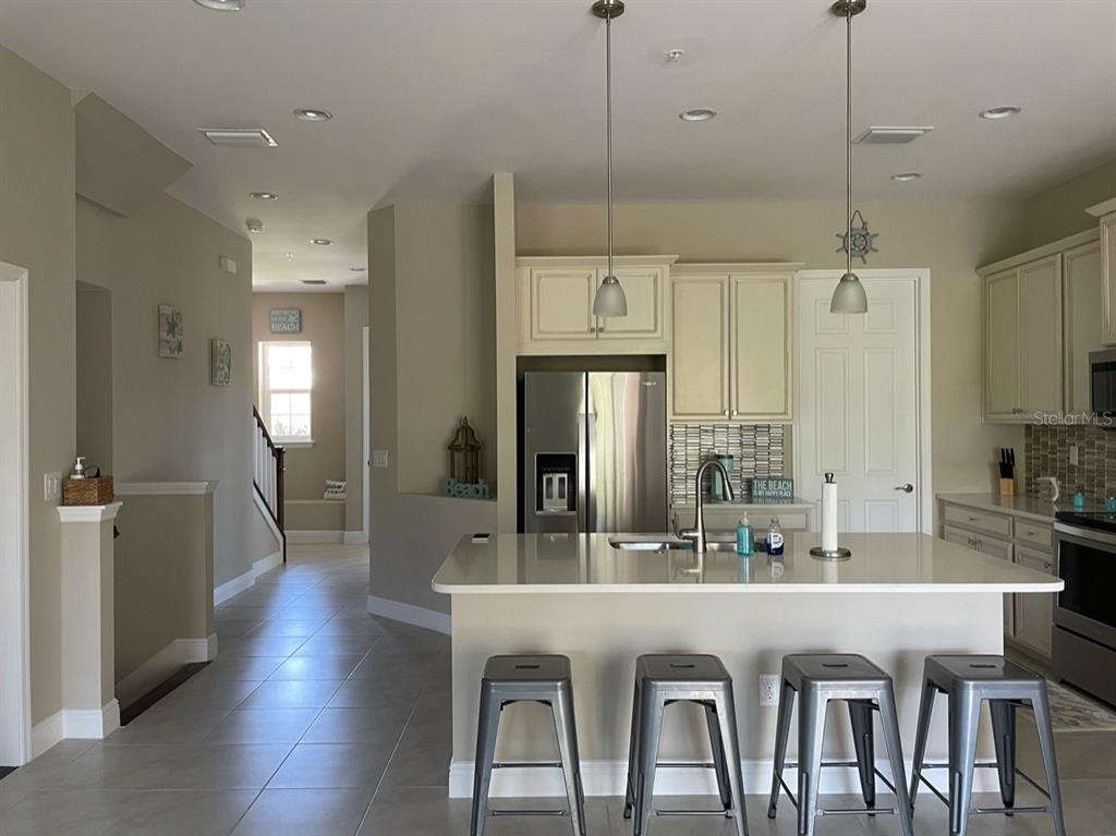 10425 Pilothouse Circle, Unit 130 Placida, FL 33946 - Photo 14 of 76 a kitchen with stainless steel appliances granite countertop a dining table chairs and white cabinets