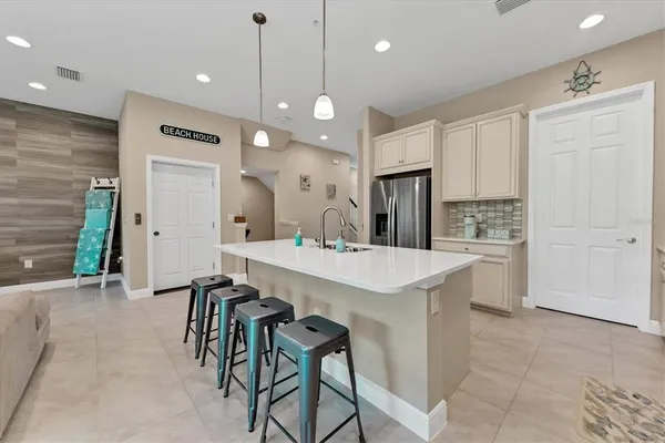 a kitchen with white cabinets and sink