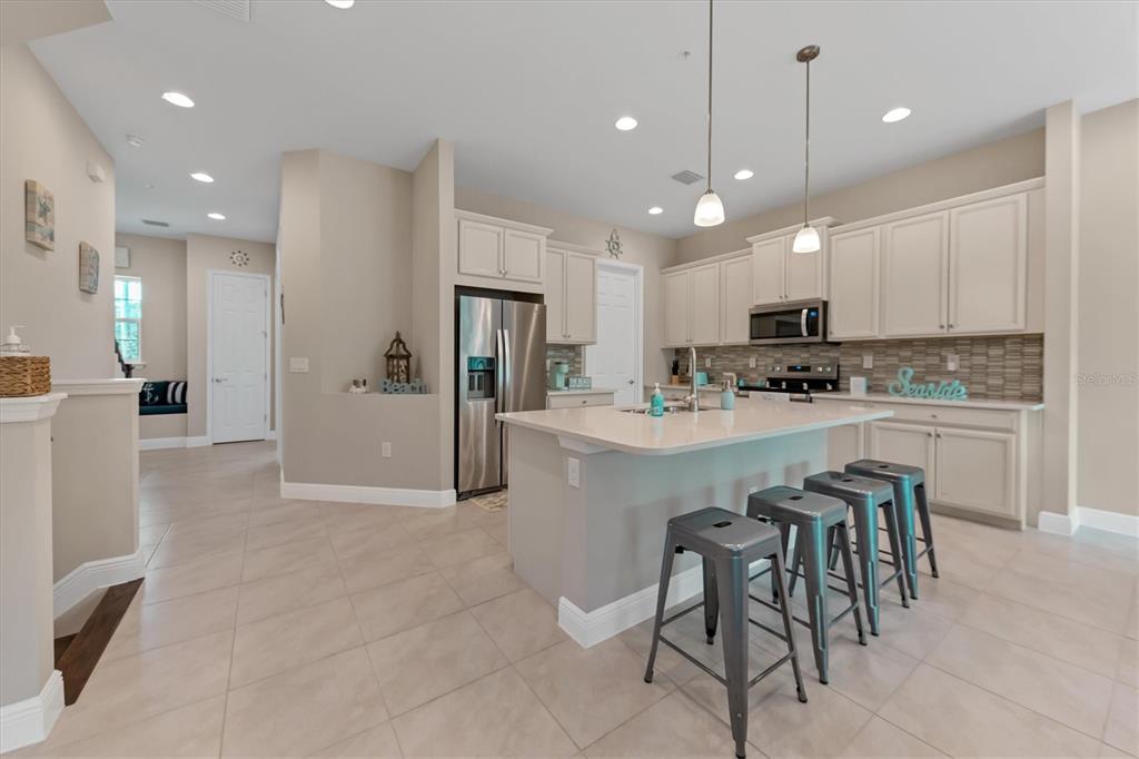 10425 Pilothouse Circle, Unit 130 Placida, FL 33946 - Photo 24 of 76 a kitchen with kitchen island granite countertop a refrigerator oven a sink and white cabinets
