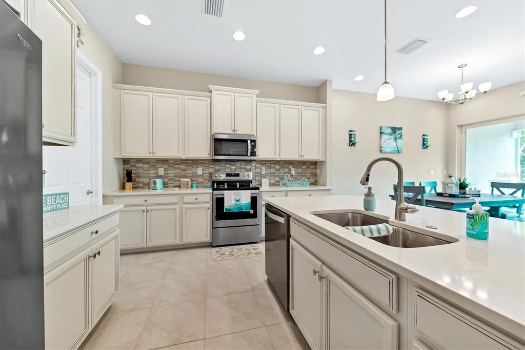 10425 Pilothouse Circle, Unit 130 Placida, FL 33946 - Photo 30 of 76 a kitchen with white cabinets and sink