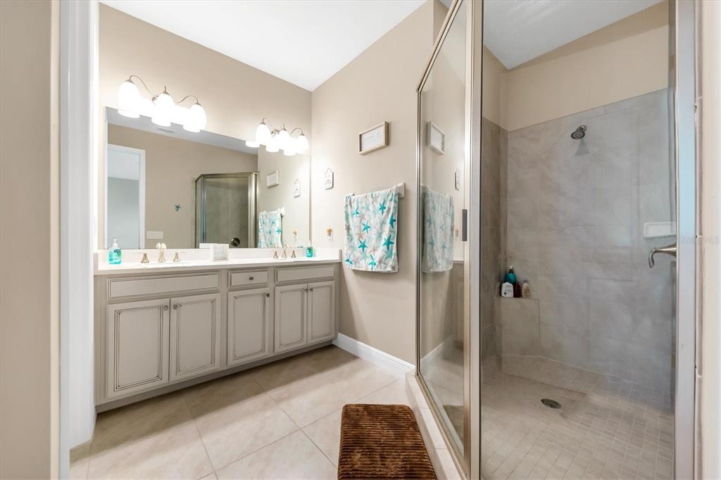10425 Pilothouse Circle, Unit 130 Placida, FL 33946 - Photo 58 of 76 a bathroom with a double vanity sink a toilet a mirror and shower