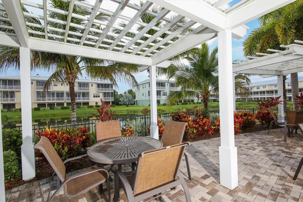 10425 Pilothouse Circle, Unit 130 Placida, FL 33946 - Photo 75 of 76 a view of a patio with a dining table and chairs with wooden floor