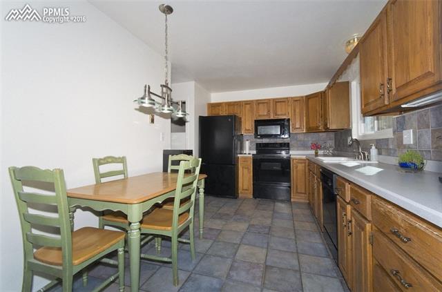 4315 Red Forest Road Monument, CO 80132 - Photo 21 of 32 tile backsplash and matching tile floor in kitchen