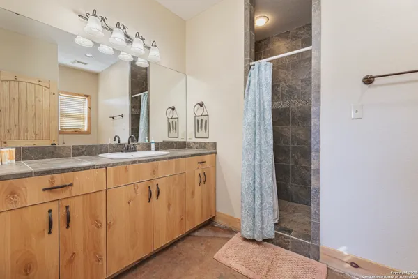 a bathroom with a double vanity sink mirror and shower