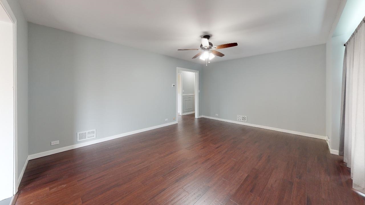 7624 Forest Avenue Munster, IN 46321 - Photo 13 of 37 a view of an empty room with wooden floor and a ceiling fan