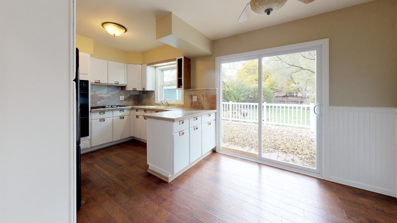 7624 Forest Avenue Munster, IN 46321 - Photo 16 of 37 a kitchen with stainless steel appliances granite countertop a stove a sink and white cabinets with wooden floors