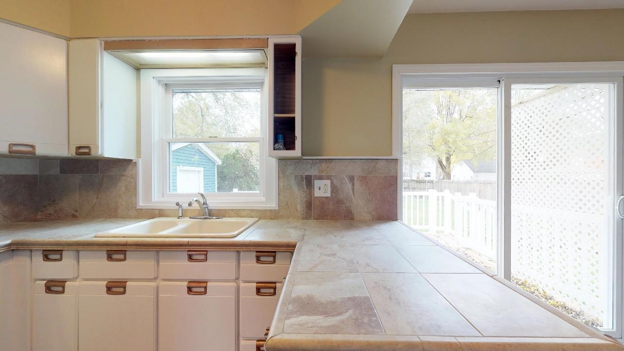 7624 Forest Avenue Munster, IN 46321 - Photo 21 of 37 a spacious bathroom with a granite countertop sink and a mirror