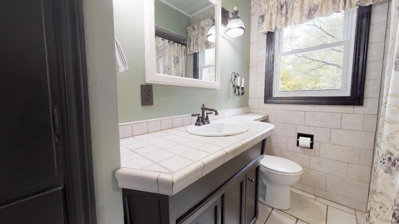 7624 Forest Avenue Munster, IN 46321 - Photo 29 of 37 a bathroom with a sink a toilet and a window