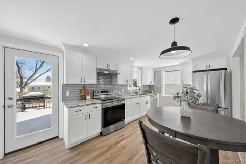 a kitchen with stainless steel appliances granite countertop a sink a stove and refrigerator