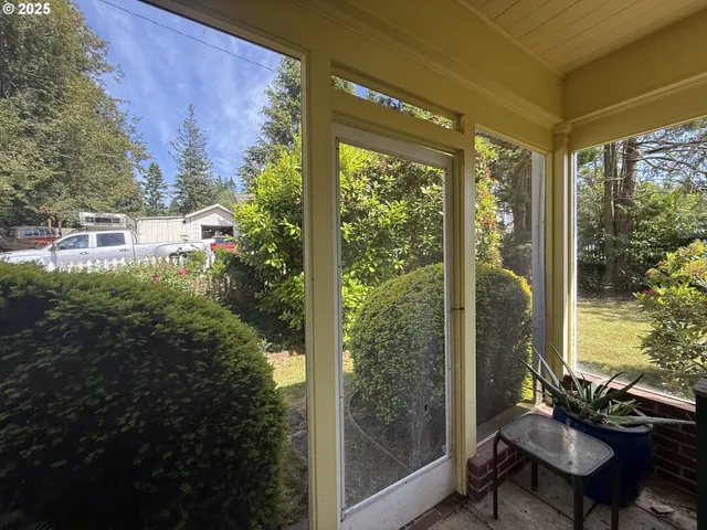 a view of a room with a large window and wooden floor