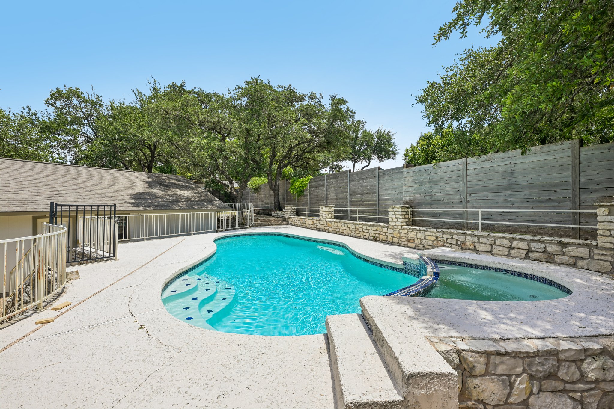 13101 Travis View Loop Austin, TX 78732 - Photo 26 of 27 An inviting backyard oasis offers a free-form swimming pool with integrated spa and ample surrounding patio.