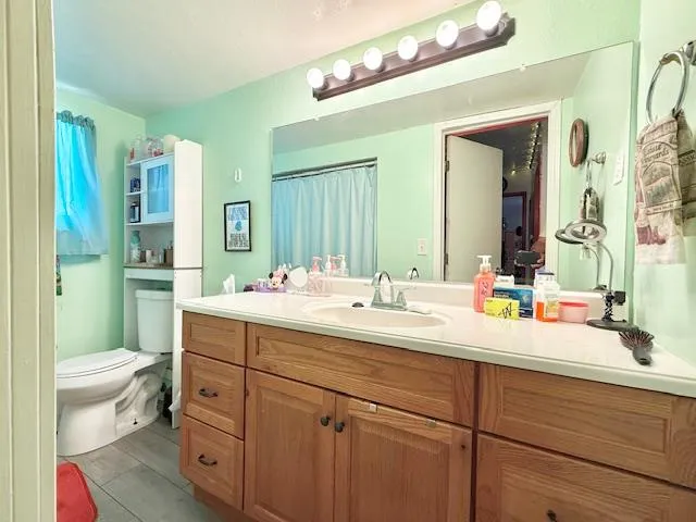 a bathroom with a sink a toilet and a mirror