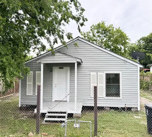 a white house that has tree in front of it