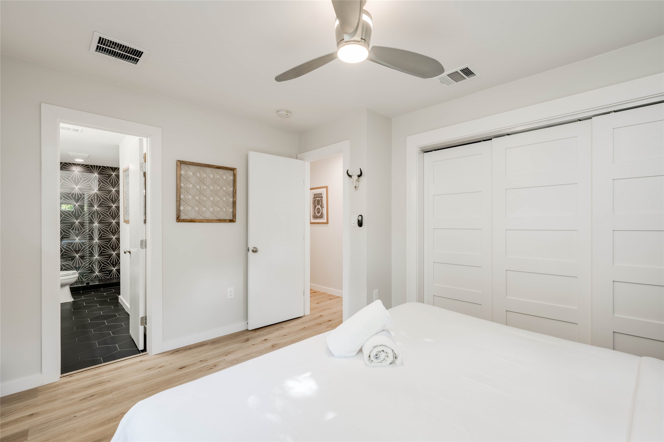 2516 Friar Tuck Lane Austin, TX 78704 - Photo 20 of 40 a bedroom with a bed and a chandelier fan