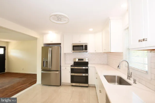 a kitchen with granite countertop a refrigerator and a sink