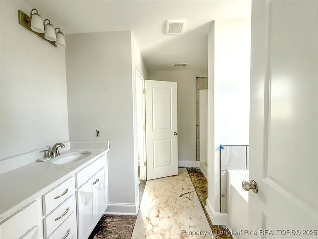 a spacious bathroom with a double vanity sink a mirror and a shower