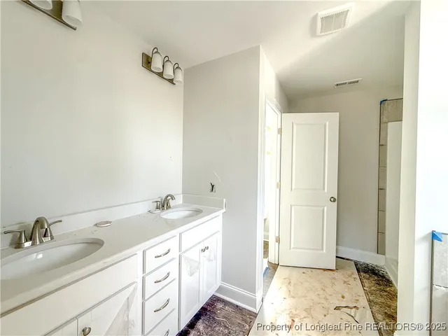 a spacious bathroom with a double vanity sink a mirror and a