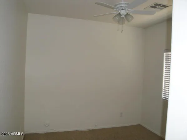 an empty room with a window and a fan